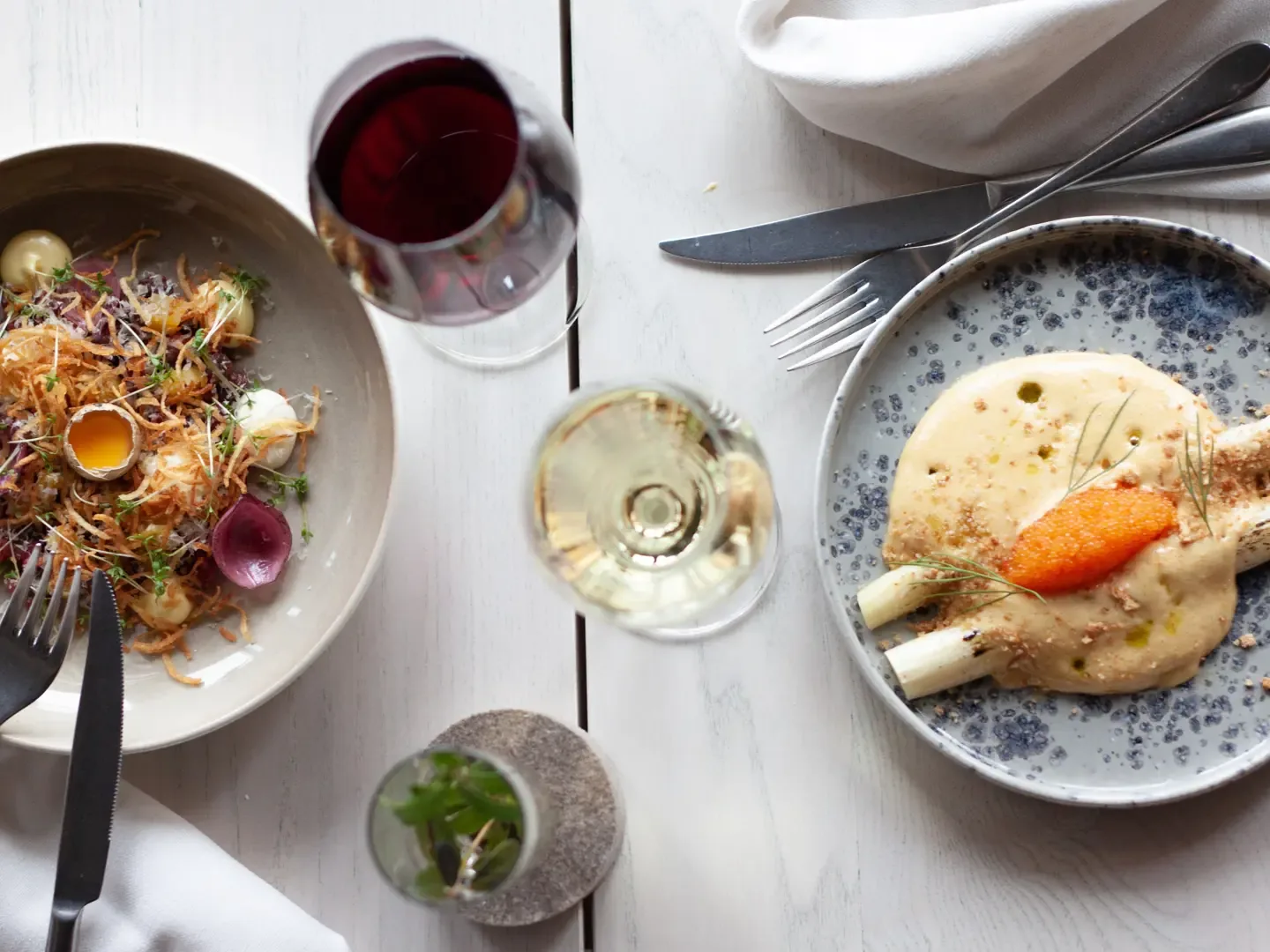 A northern-inspired dish served at Restaurant Fe in Kiruna, with warm candlelight and rustic table settings