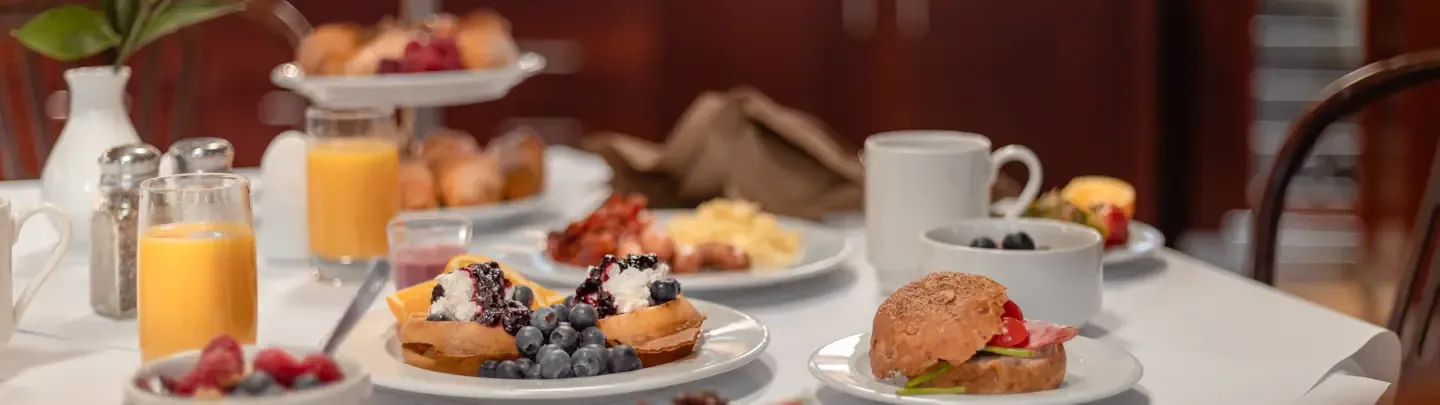 Breakfast table at Elite Hotel Frost with waffles, berries, juice and coffee