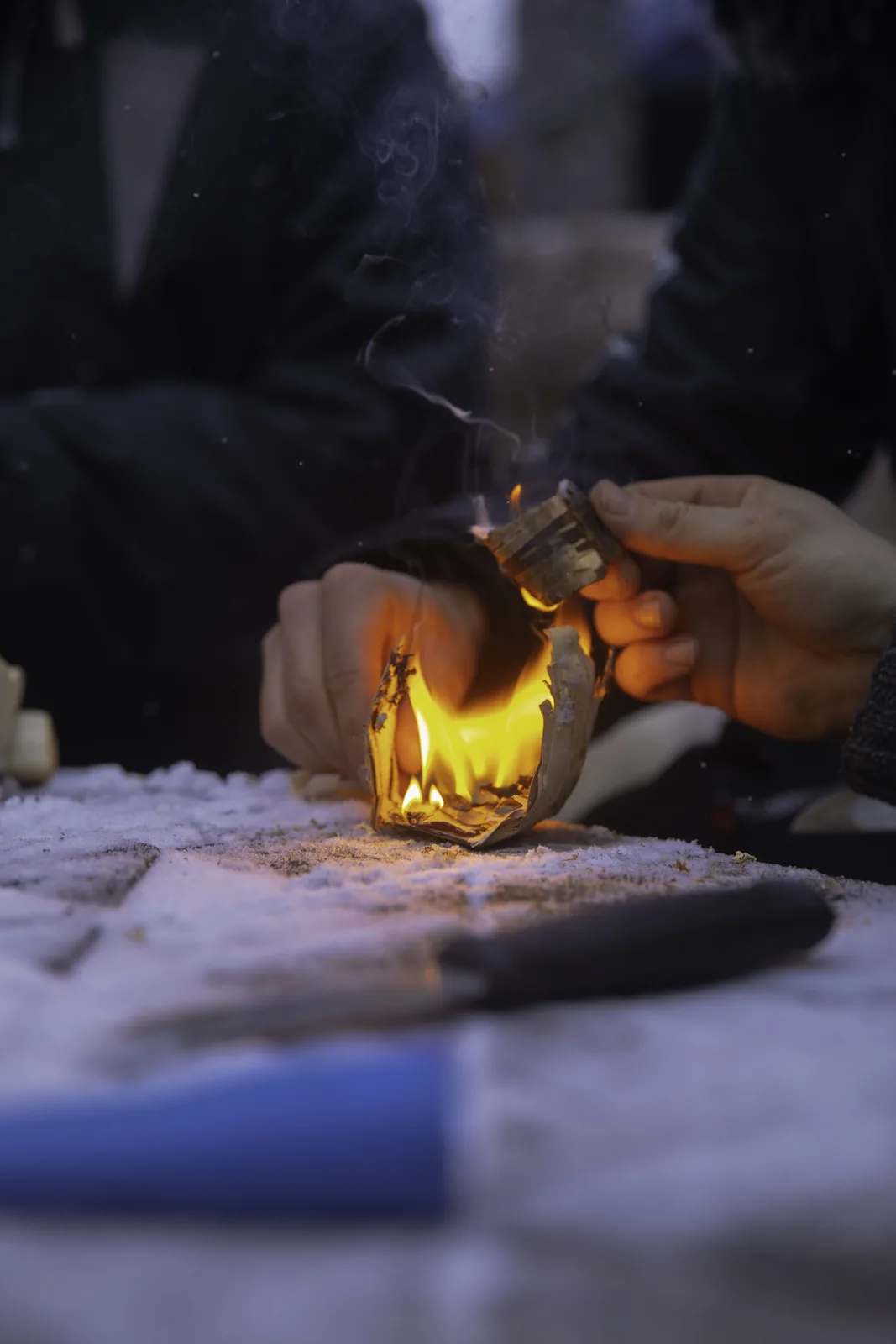 Close-up of hands lighting the open fire with a flint
