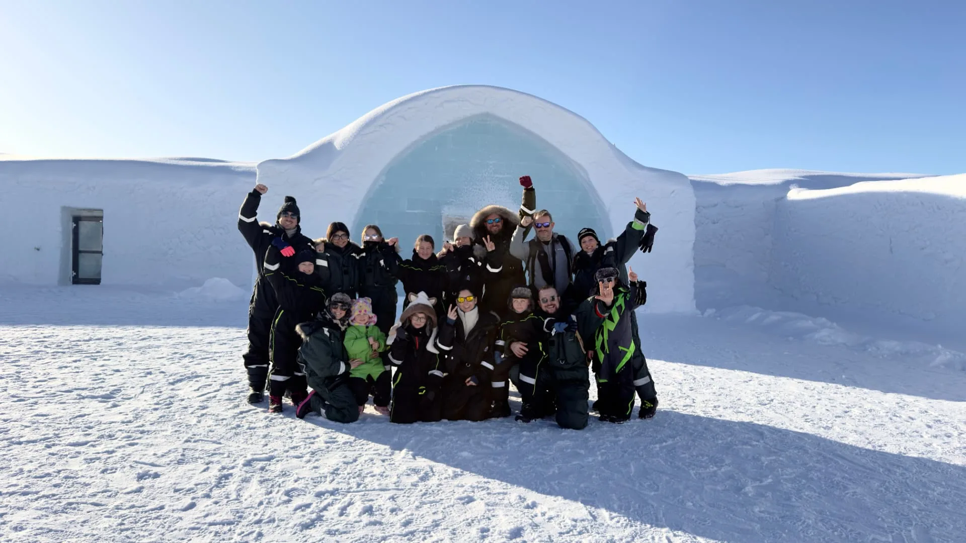 Guest group at the arched ice entrance of the ICEHOTEL in Jukkasjärvi near Kiruna