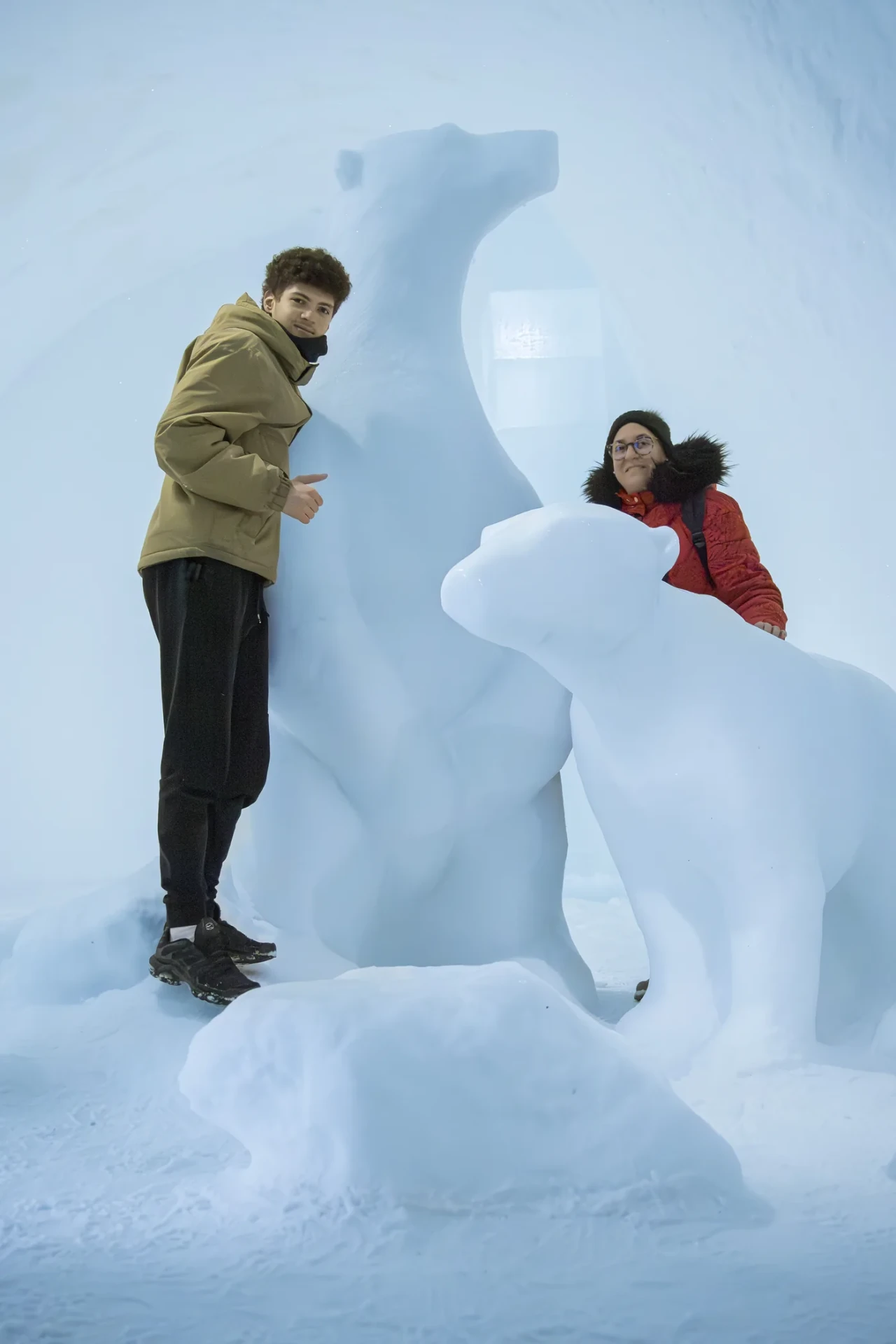Guests beside a polar bear sculpture carved from ice