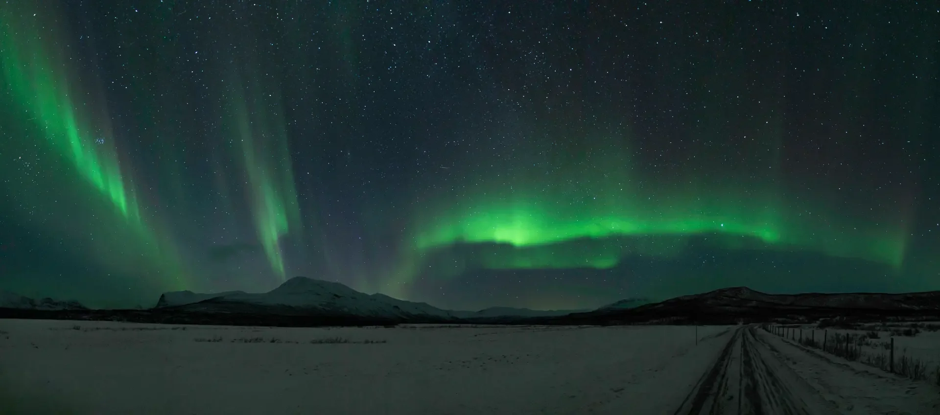Northern lights panorama over a frozen lake outside Kiruna, Swedish Lapland