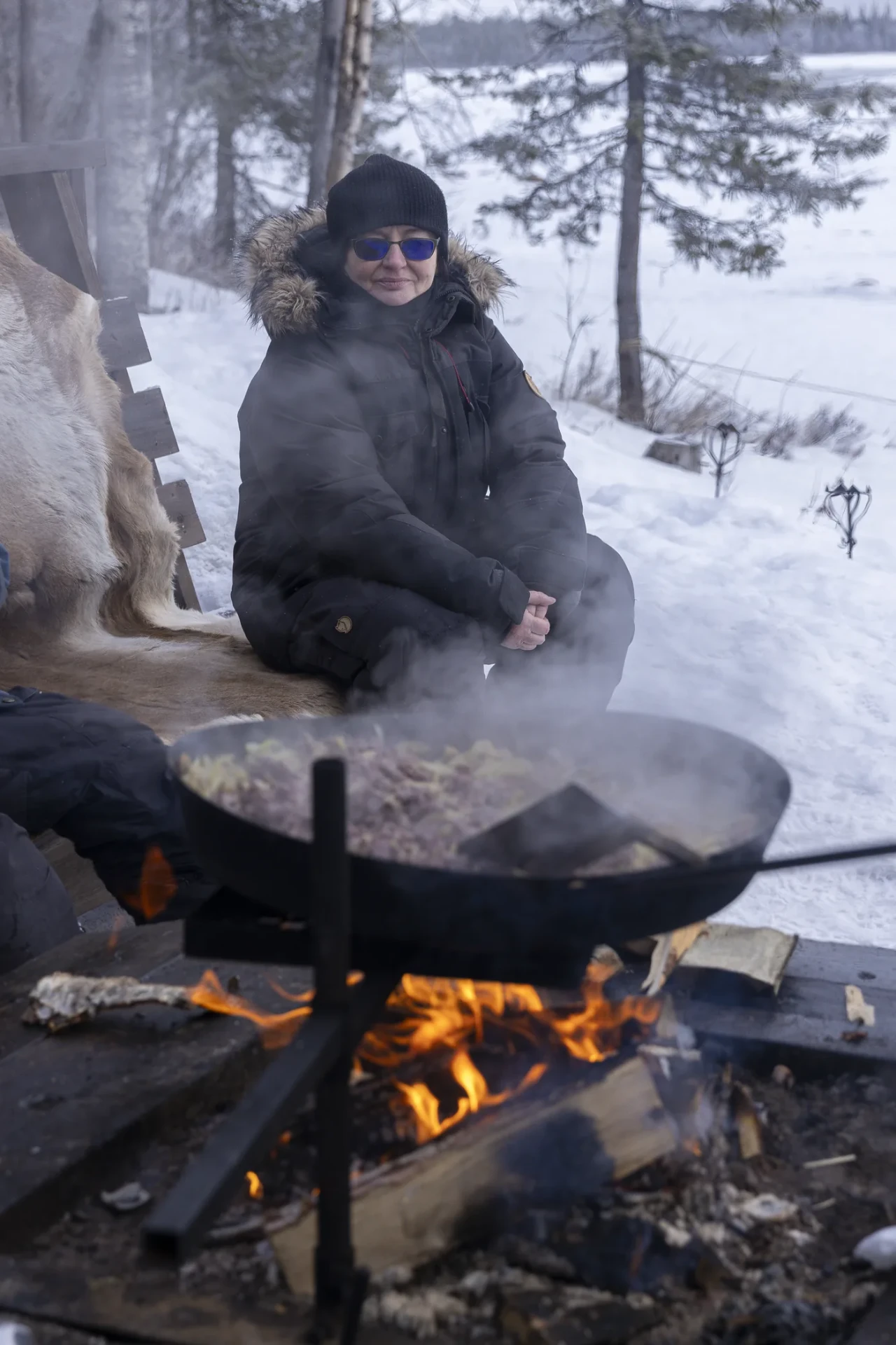 Guest helping prepare food over a fire during the week