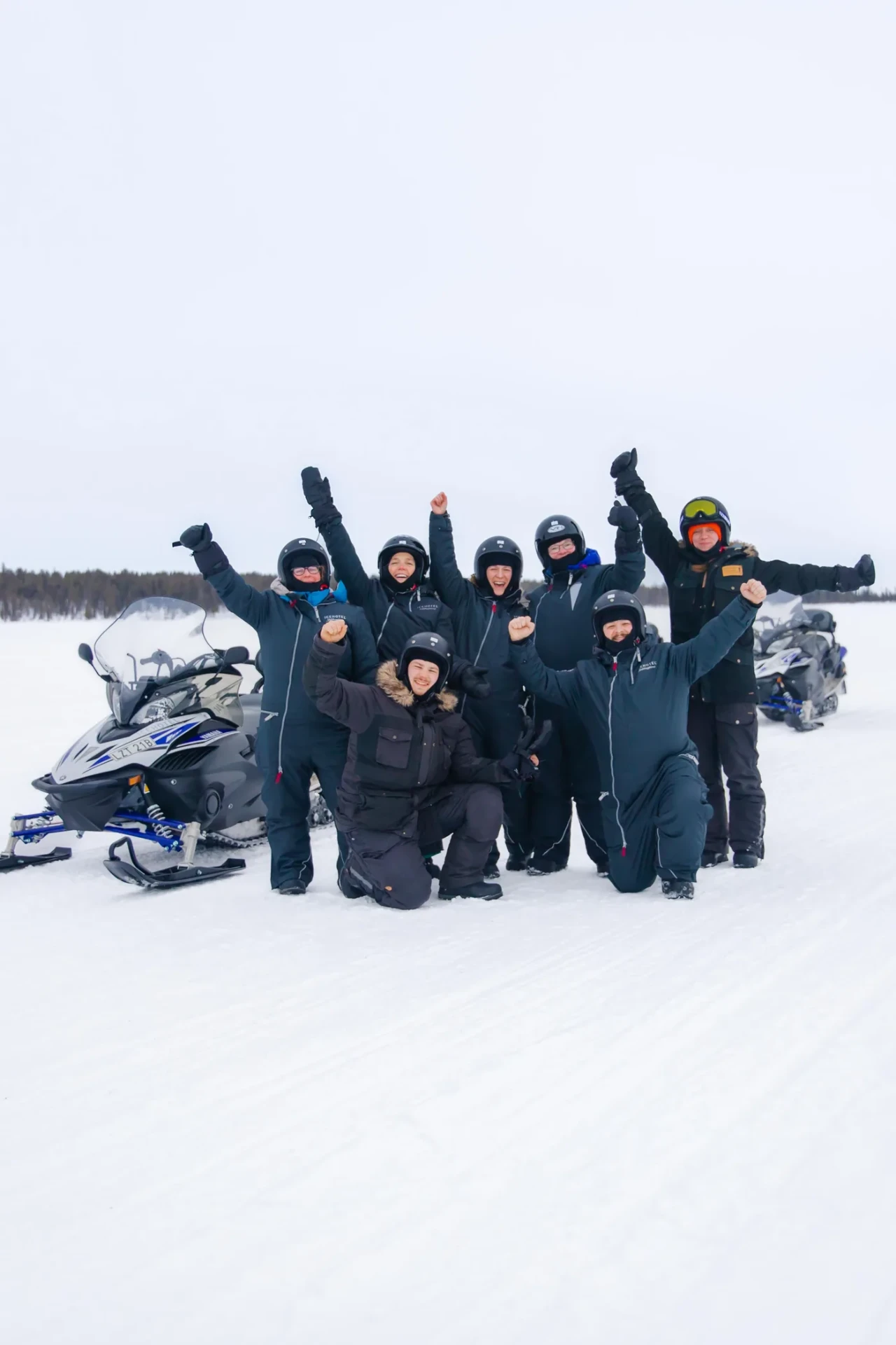 Our guest group standing with their snowmobiles out on a frozen lake near Kiruna